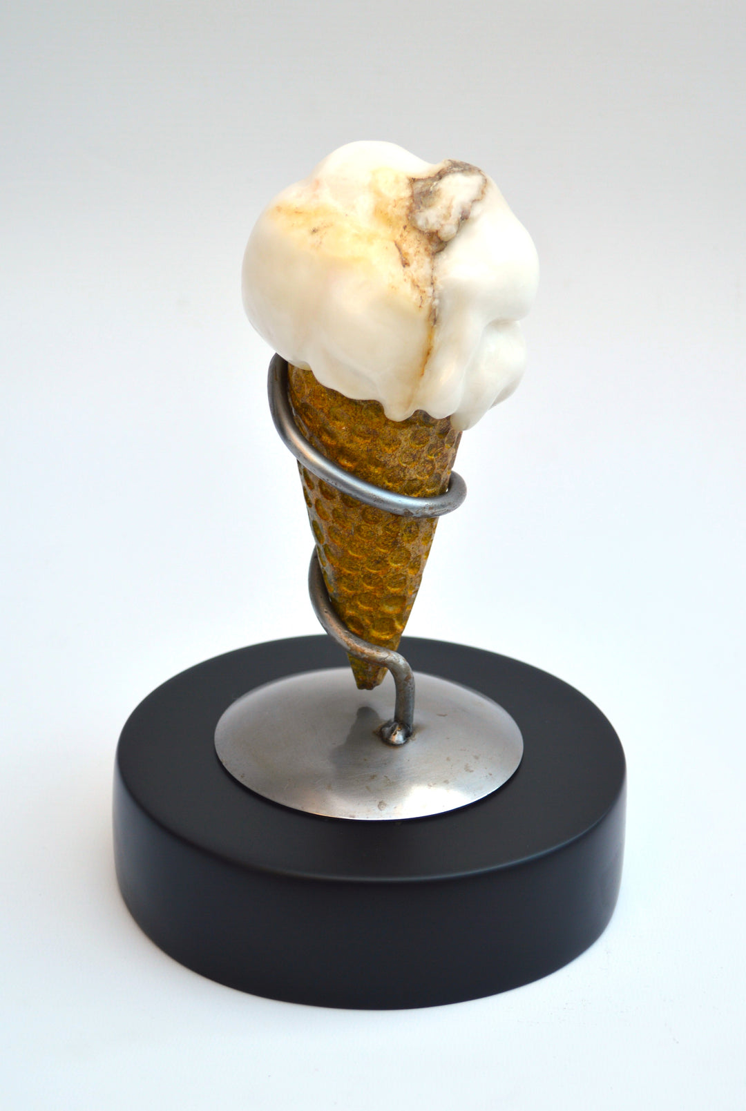 Deborah Harrison alabaster sculpture Ice Cream, one-off artwork featuring a hand-carved alabaster scoop with natural cream and golden brown veining, set in an Ancaster limestone cone, secured by a polished steel spiral holder on a slate base, blending playfulness with fine craftsmanship.