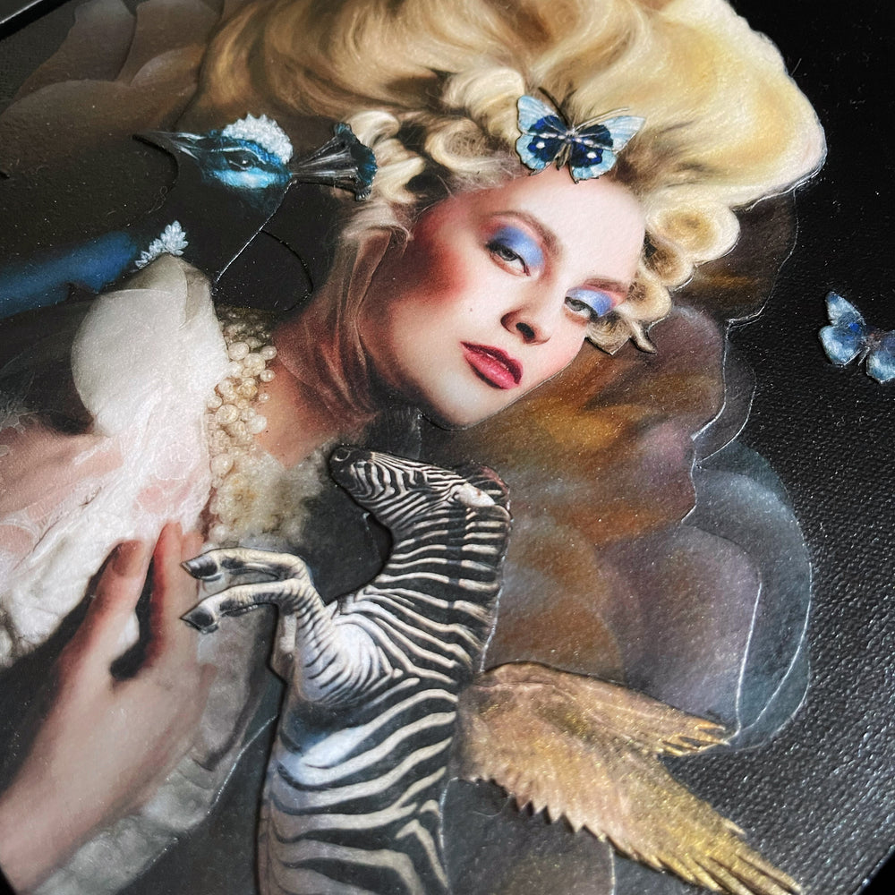 Catarina Diaz’s If We Ever, analogue collage on Somerset Enhanced Velvet with oil on gesso-primed canvas. Blonde woman in elaborate ivory gown and pearls, towering coiffure adorned with blue butterflies, flanked by blue peacock and winged zebra, floral backdrop.