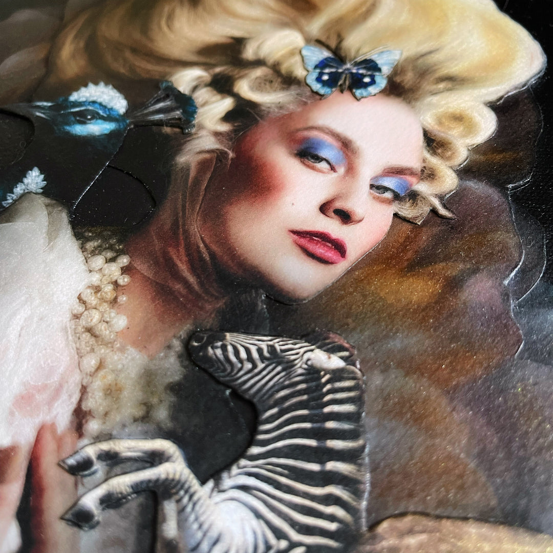 Catarina Diaz’s If We Ever, analogue collage on Somerset Enhanced Velvet with oil on gesso-primed canvas. Blonde woman in elaborate ivory gown and pearls, towering coiffure adorned with blue butterflies, flanked by blue peacock and winged zebra, floral backdrop.