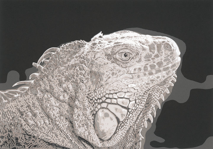 Hand-cut paper artwork of an iguana, showcasing its intricate scales and textured ridges in layered tones of ivory, taupe, and soft grey. Each scale is individually cut, creating a strikingly lifelike, prehistoric presence against a deep charcoal background.
