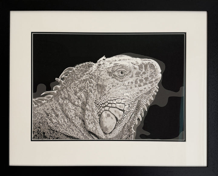 Hand-cut paper artwork of an iguana, showcasing its intricate scales and textured ridges in layered tones of ivory, taupe, and soft grey. Each scale is individually cut, creating a strikingly lifelike, prehistoric presence against a deep charcoal background.