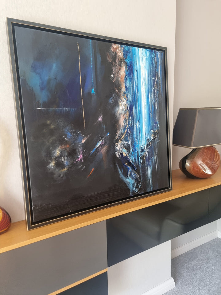 Abstract mixed-media painting in deep blues and blacks with cascading vertical textures, bright aqua highlights and metallic gold accents, featuring layered fabric elements that create a sense of movement and depth against a dark atmospheric background.