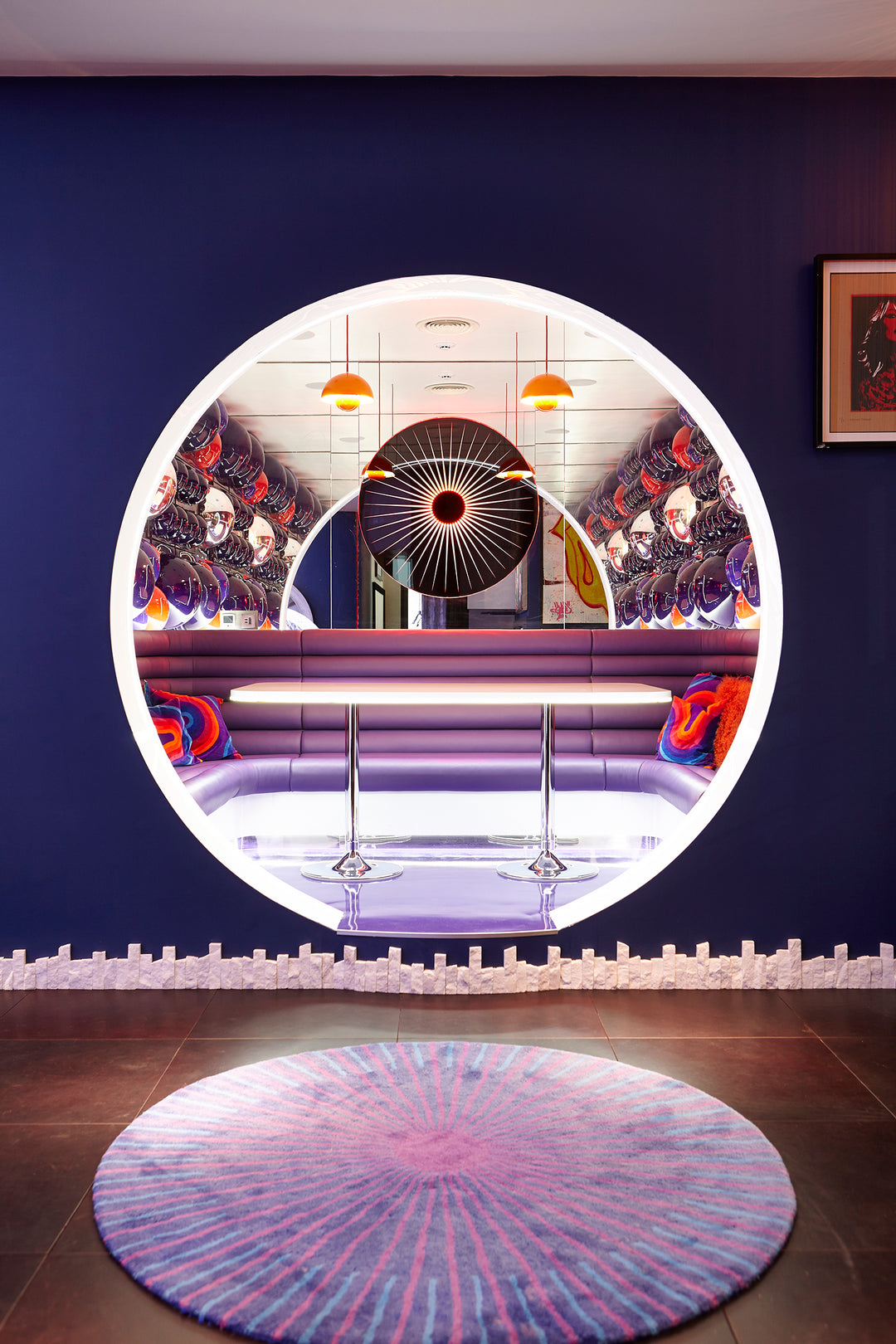 “Iris” by Ben Rousseau – a circular illuminated artwork crafted from engraved acrylic, combining nature’s geometry with digital precision. Red and amber light radiates from the centre, evoking the structure of a human iris in sculptural form.

