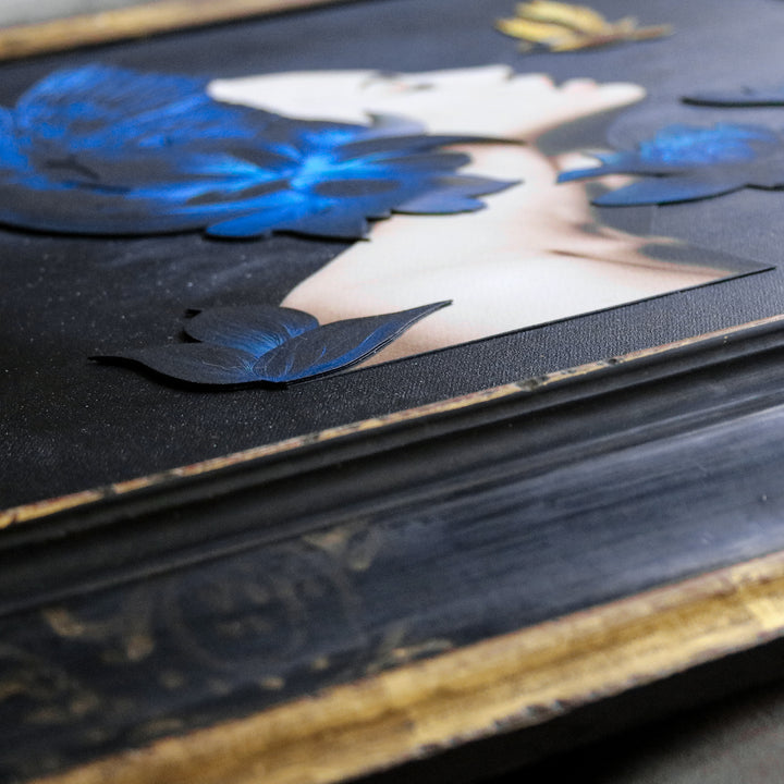 Catarina Diaz’s I See, an analogue collage on Somerset Enhanced Velvet with oil on canvas board. A serene female profile adorned with vivid blue feathers and lotus blooms faces a golden-yellow hummingbird, all set against a starry black backdrop in an antique gallery frame.