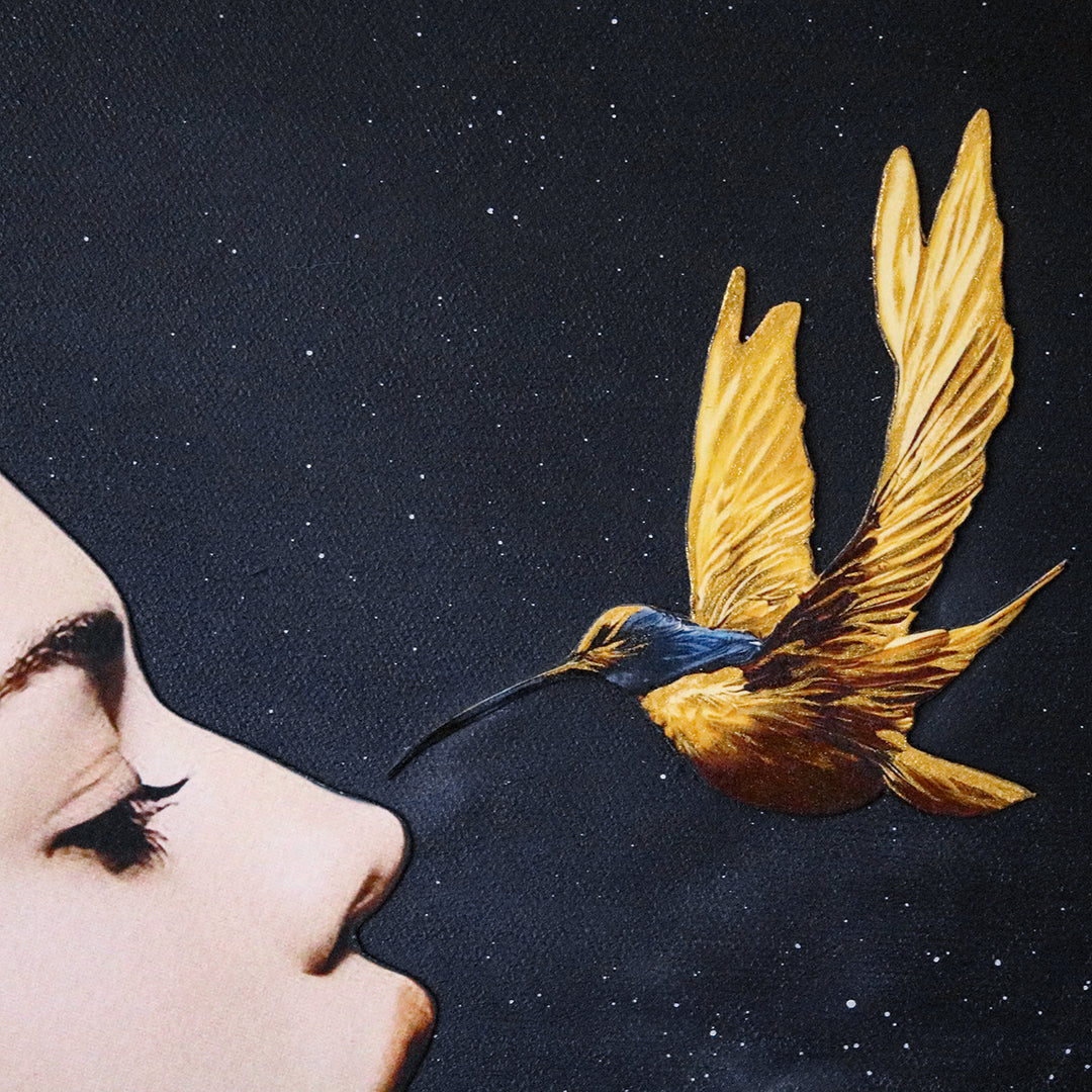 Catarina Diaz’s I See, an analogue collage on Somerset Enhanced Velvet with oil on canvas board. A serene female profile adorned with vivid blue feathers and lotus blooms faces a golden-yellow hummingbird, all set against a starry black backdrop in an antique gallery frame.