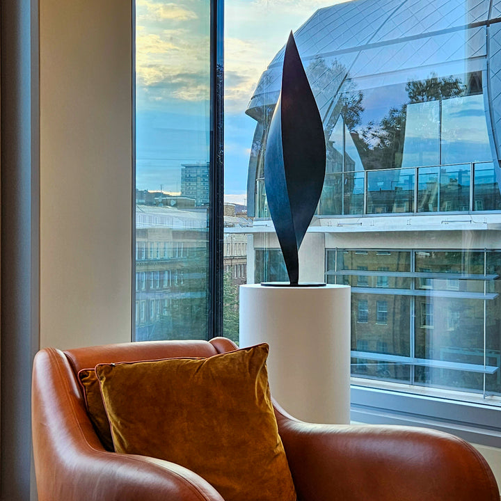 Patinated bronze Leaf sculpture by James Parker, with a gently twisting three-sided form inspired by balance, movement and natural renewal.