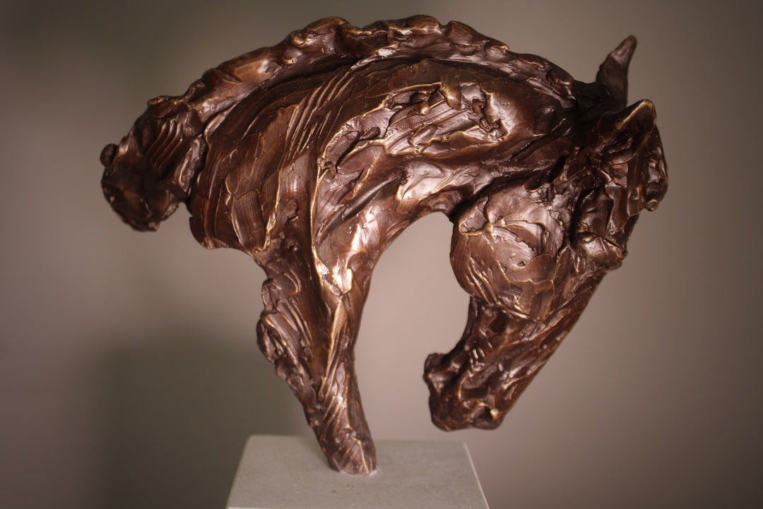 Bronze sculpture of an arched horse head with expressive detailing, mounted on a minimalist Portland stone base against a soft neutral backdrop.