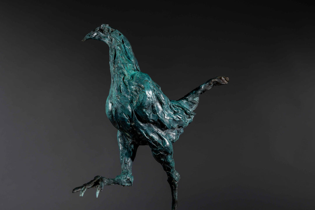 Bronze sculpture of a proud gaming cockerel mid-stride, with elongated legs and intricate feather textures, finished in a rich verdigris patina, mounted on a slate base.