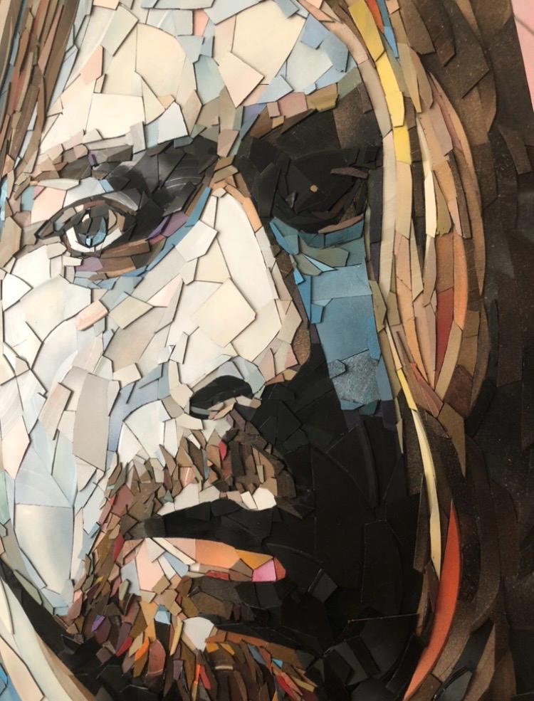 Ed Chapman mosaic portrait of Kurt Cobain crafted entirely from broken vinyl records, with layered shards forming a striking likeness of the Nirvana frontman against a soft pink background.