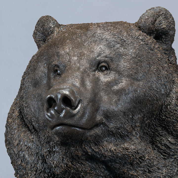 Large bronze head study of a Kodiak brown bear by Nick Bibby, showing powerful form, dense textured fur and rich brown patina, mounted on a tall bronze plinth with mottled green and earthy tones.