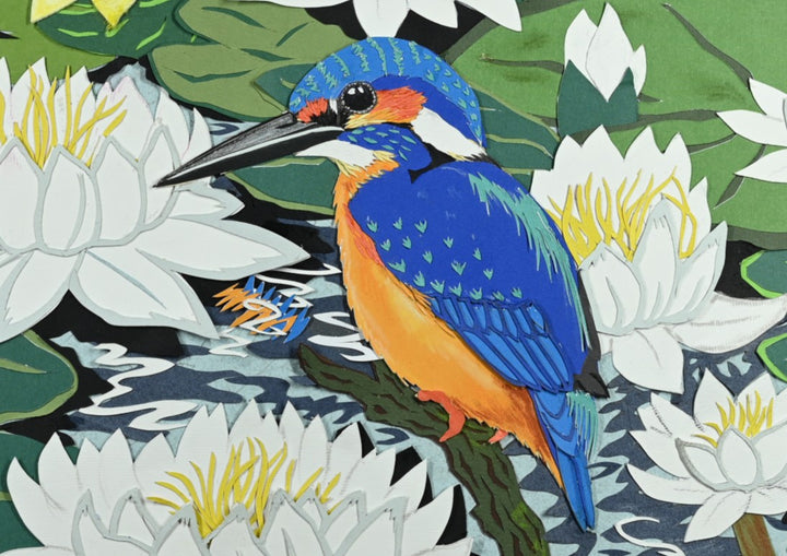 Cut-paper artwork featuring two vibrant kingfishers perched among white and yellow waterlilies, pink blossoms and layered green leaves, with rippling dark water adding movement to this colourful, nature-rich scene.