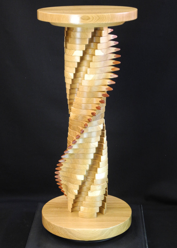 Lacuna Table 2 by Max McCance — a one-off sculptural table in oak and mahogany with a twisting double-helix column and sharp mahogany points spiralling upward beneath a round oak top and base.