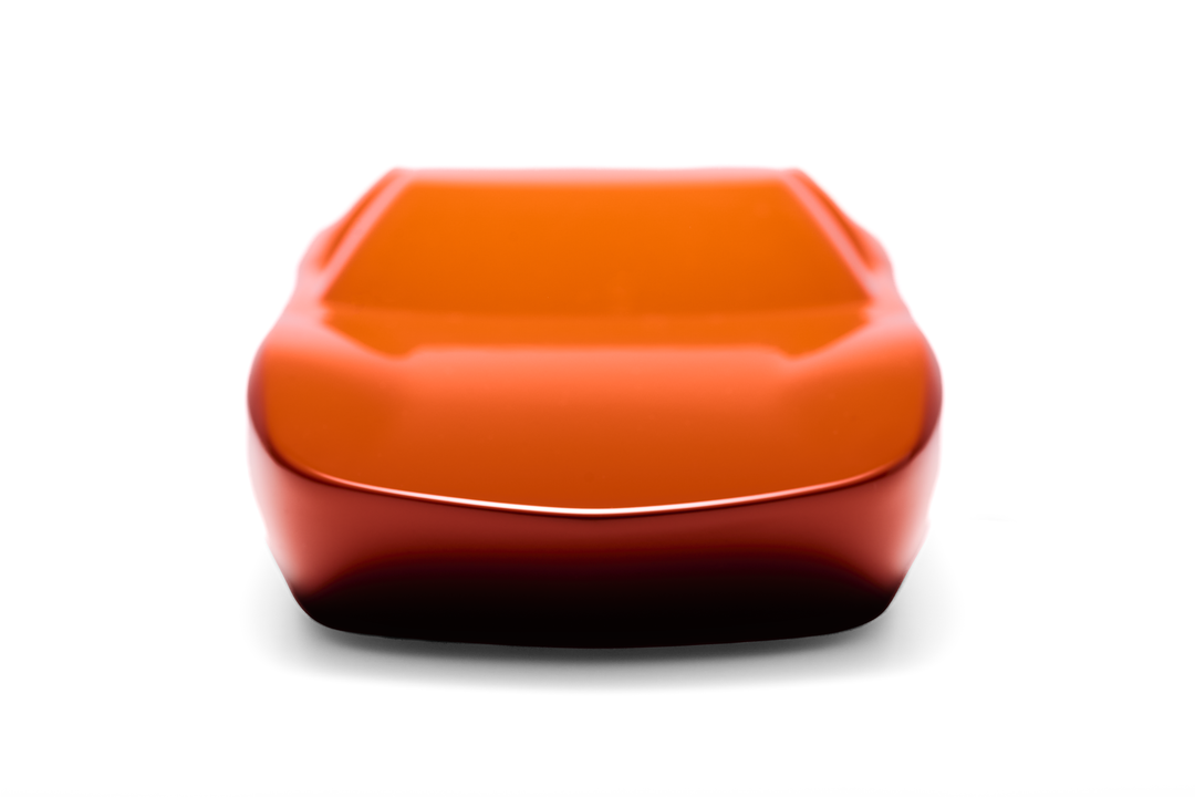 ‘Lamborghini Miura’ by Srini Gandra, a limited-edition contemporary automotive sculpture from the Forme di Velocità series, inspired by the legendary Lamborghini Miura designed by Marcello Gandini at Bertone. Presented in a vibrant high-gloss Arancio Miura orange finish, the sculpture captures the supercar's low, flowing silhouette, elongated bonnet, sculpted wheel arches, sweeping side contours and distinctive fastback profile. Its smooth, minimalist surfaces celebrate the aerodynamic elegance and timeless