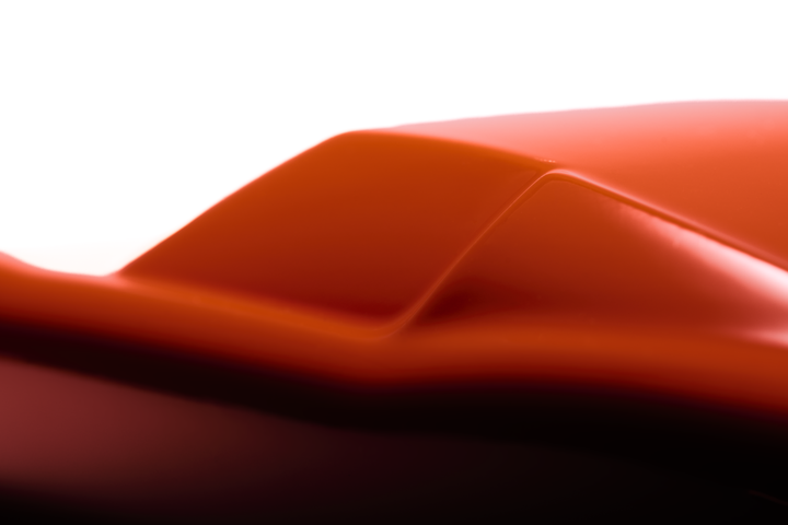 ‘Lamborghini Miura’ by Srini Gandra, a limited-edition contemporary automotive sculpture from the Forme di Velocità series, inspired by the legendary Lamborghini Miura designed by Marcello Gandini at Bertone. Presented in a vibrant high-gloss Arancio Miura orange finish, the sculpture captures the supercar's low, flowing silhouette, elongated bonnet, sculpted wheel arches, sweeping side contours and distinctive fastback profile. Its smooth, minimalist surfaces celebrate the aerodynamic elegance and timeless