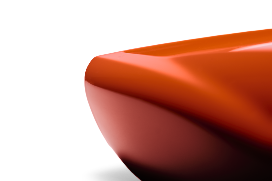 ‘Lamborghini Miura’ by Srini Gandra, a limited-edition contemporary automotive sculpture from the Forme di Velocità series, inspired by the legendary Lamborghini Miura designed by Marcello Gandini at Bertone. Presented in a vibrant high-gloss Arancio Miura orange finish, the sculpture captures the supercar's low, flowing silhouette, elongated bonnet, sculpted wheel arches, sweeping side contours and distinctive fastback profile. Its smooth, minimalist surfaces celebrate the aerodynamic elegance and timeless