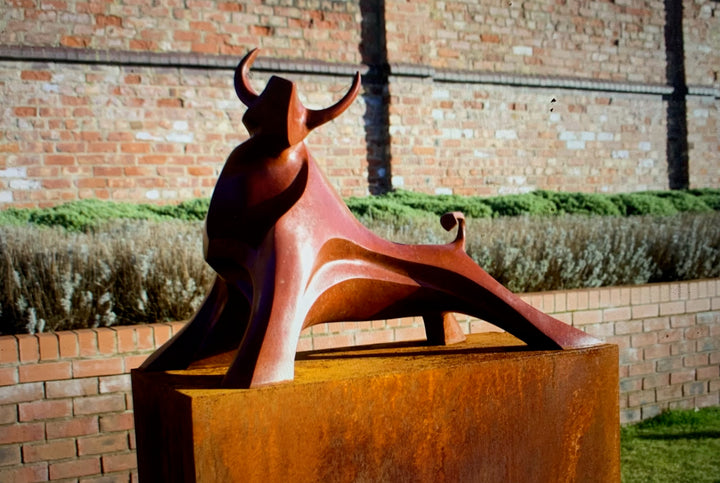 Marie Ackers The Large Red Bull sculpture — dynamic abstract bull in bronze or resin, limited edition of 8. Strong red patina, horns raised, body flowing in geometric curves. Suitable for indoor display, gardens, and public spaces.