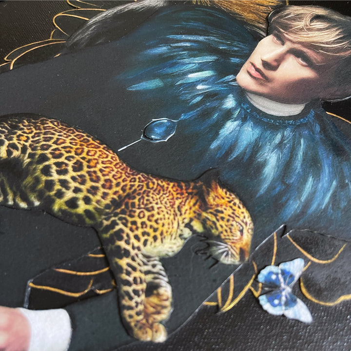 Catarina Diaz’s Let Me Hold You, analogue collage on Somerset Enhanced Velvet with oil on gesso-primed canvas. Blonde man in black with blue feathered collar, crowned crane, leopard, and blue butterfly, set against a deep black backdrop with gold accents.