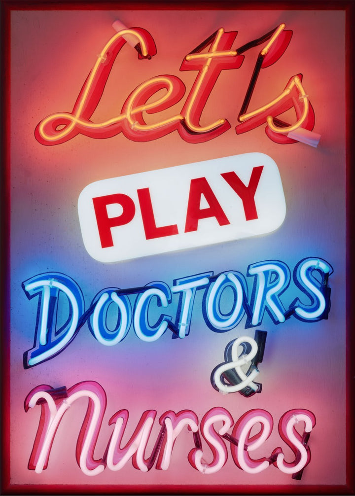 A vibrant neon sign artwork by Matthew Bracey reading “Let’s Play Doctors & Nurses.” The piece features glowing script and block fonts in red, white, blue, and pink neon set against a dark framed background, combining retro humour with bold visual impact.