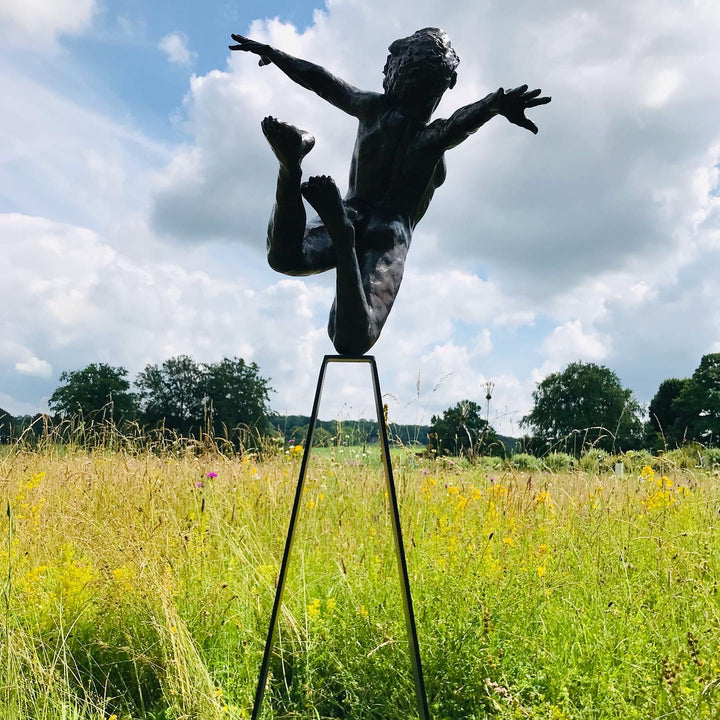 Teresa Wells’ bronze sculpture Liberty (2019), limited edition of 12, depicting a nude female figure in a dynamic leap with arms and head thrown back, one leg extended and the other bent mid-air. Cast in warm patinated bronze and mounted on a tall, powder-coated steel plinth, the piece balances elegance, athleticism, and expressive movement. At 98cm × 60cm × 190cm and 95kg, it is suited for both interior display and sheltered outdoor settings, with fine anatomical detailing smooth contours.