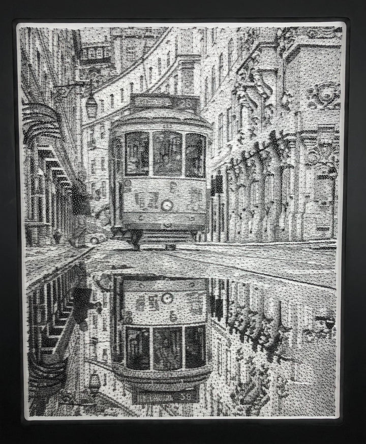 Intricate monochrome nail and string artwork of a Lisbon tram gliding through a historic street, with its reflection perfectly mirrored in a wet cobbled road.