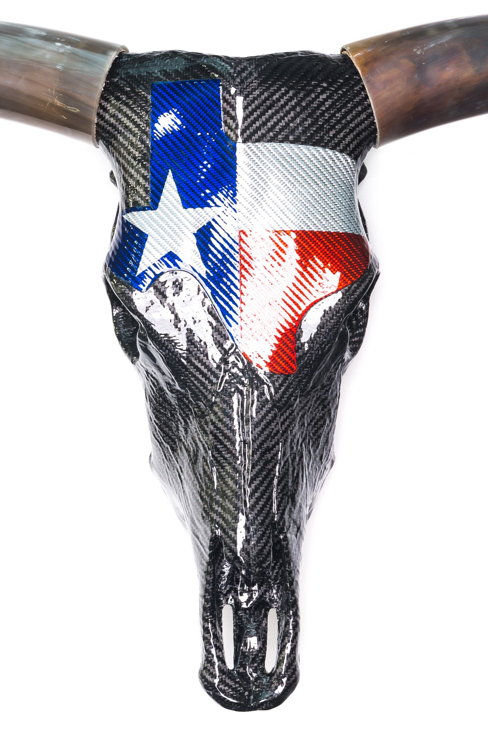 Wall-mounted sculpture of a real Texas Longhorn steer skull wrapped in glossy black carbon fibre with a bold Texan flag design in red, white, and blue Texalium across the forehead. The original curved horns are polished to a brown-black gradient, while titanium nose fittings and colour-coated teeth add Formula 1 detailing. A striking fusion of nature, motorsport, and modern material engineering.