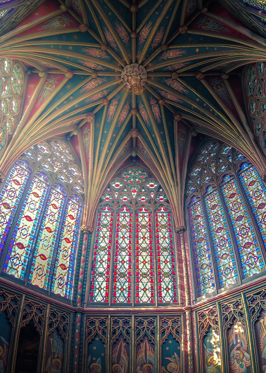 Expansive panoramic view of Ely Cathedral’s octagonal lantern tower, showing intricate stained glass, fan-vaulted roof, and painted saints, bathed in radiant light and medieval detail.