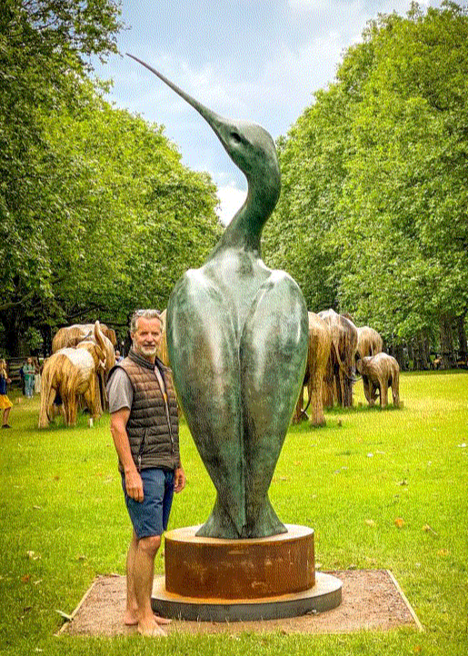 Simon Gudgeon bronze sculpture Luna featuring an elegant abstract curlew-inspired bird form with sweeping curved lines displayed within landscaped garden settings.
