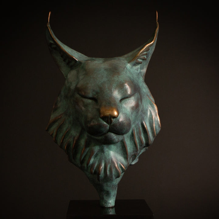 Petra Eurasian Lynx bronze sculpture by Min Reid, serene lynx head with closed eyes and pointed ear tufts in green verdigris bronze with warm copper highlights, mounted on a black plinth, contemporary wildlife bronze sculpture