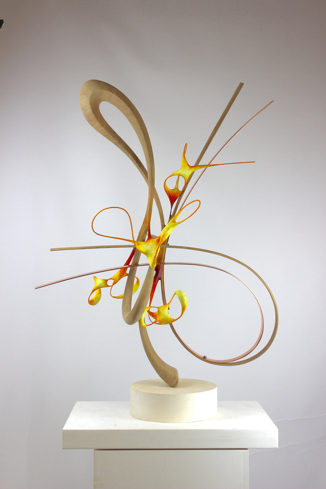 Sculptural artwork Bird of Paradise by Mark Purllant, a one-off mixed media piece combining carved and steam-bent English oak, polished copper, and painted sculptural forms in vivid red, yellow, and orange tones on a plaster base.