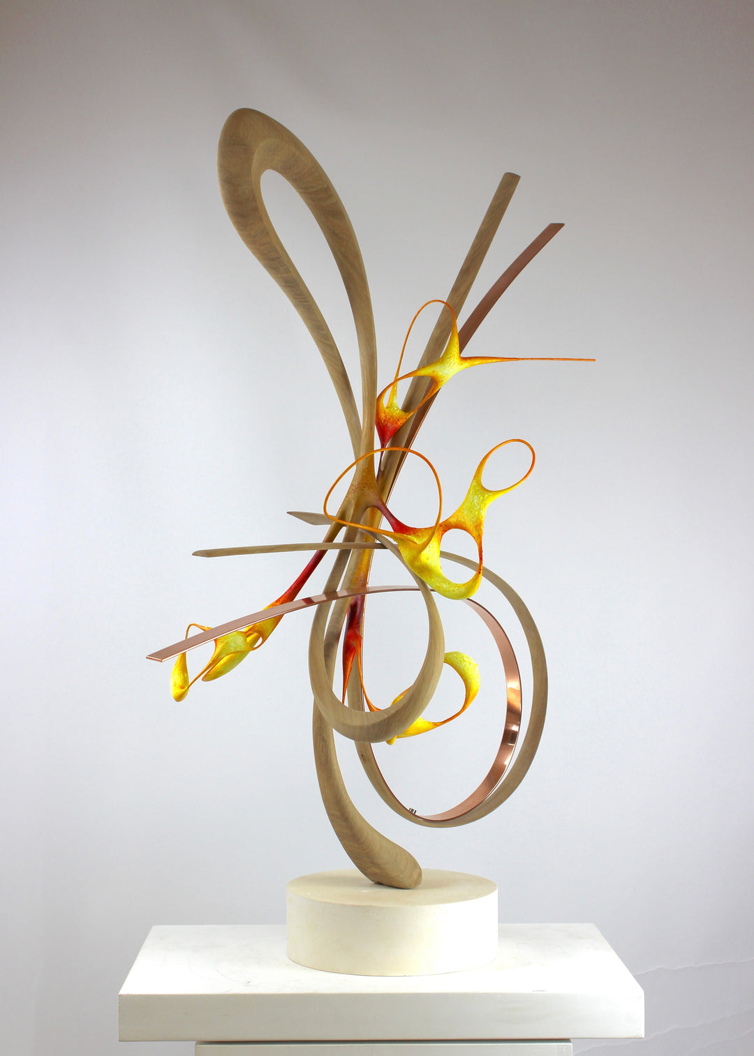 Sculptural artwork Bird of Paradise by Mark Purllant, a one-off mixed media piece combining carved and steam-bent English oak, polished copper, and painted sculptural forms in vivid red, yellow, and orange tones on a plaster base.