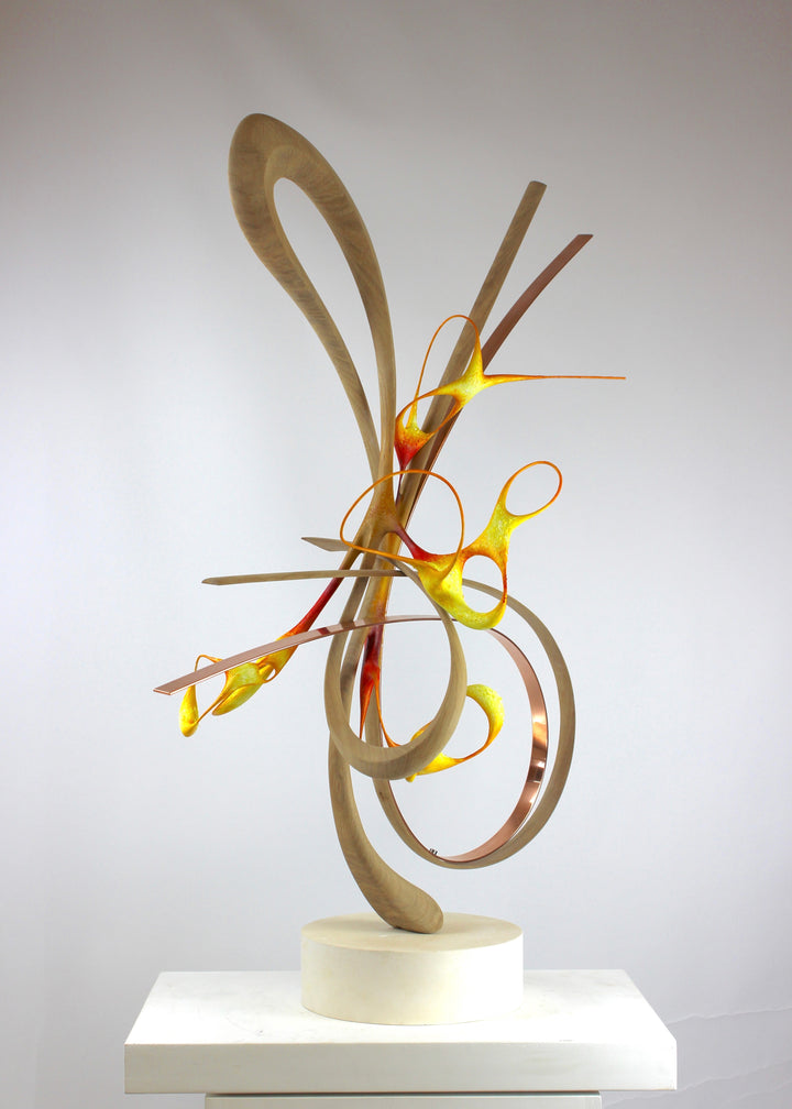 Sculptural artwork Bird of Paradise by Mark Purllant, a one-off mixed media piece combining carved and steam-bent English oak, polished copper, and painted sculptural forms in vivid red, yellow, and orange tones on a plaster base.