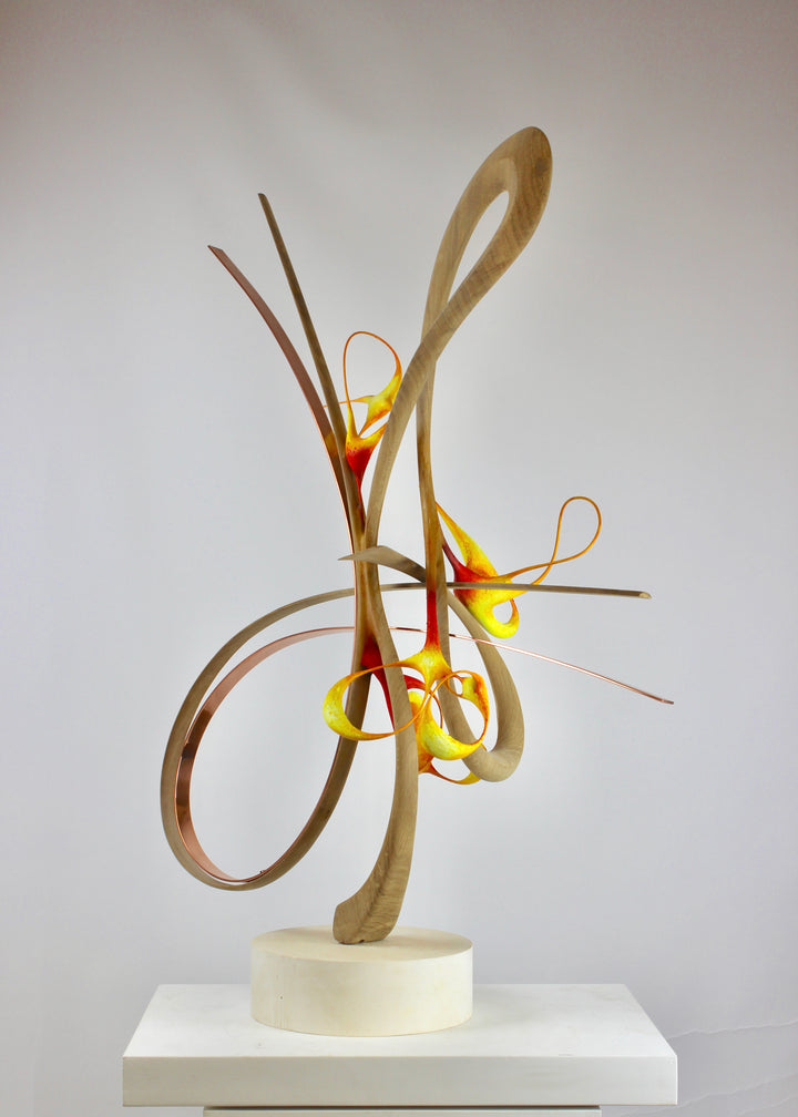 Sculptural artwork Bird of Paradise by Mark Purllant, a one-off mixed media piece combining carved and steam-bent English oak, polished copper, and painted sculptural forms in vivid red, yellow, and orange tones on a plaster base.