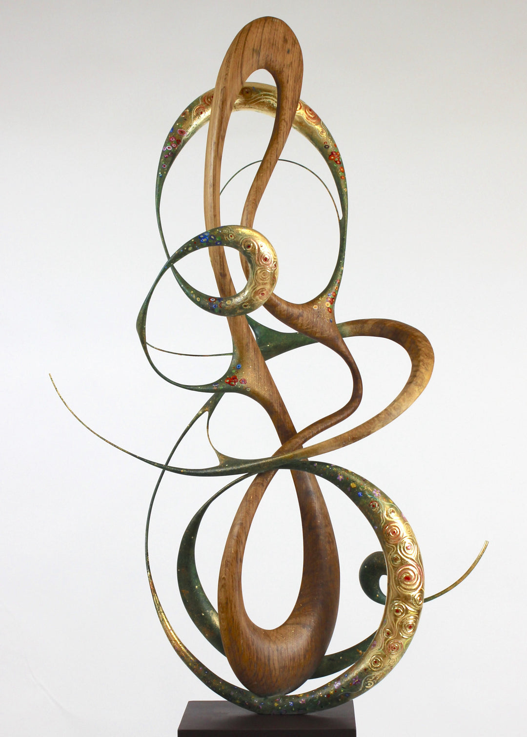 How Was I to Know by Mark Purllant, a one-off mixed media sculpture in carved English brown oak with intertwining flowing forms, enriched with painted details and 23ct gold leaf accents, evoking Gustav Klimt’s decorative influence.