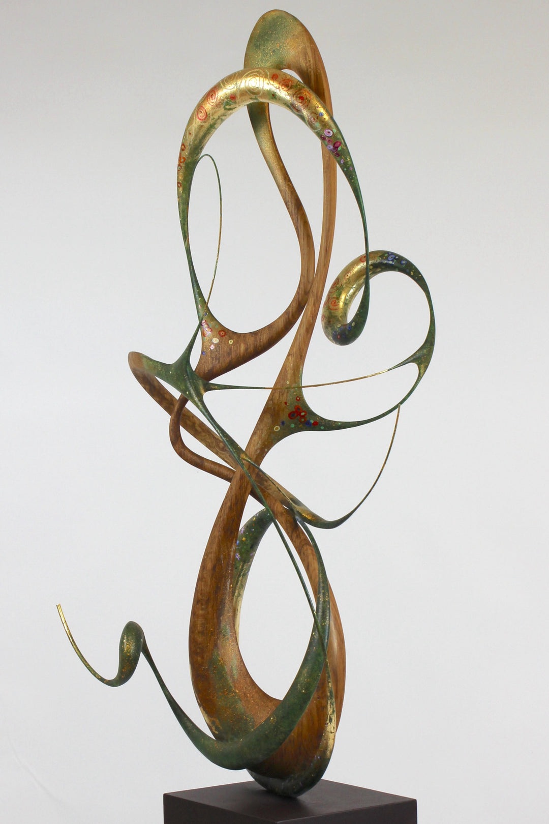 How Was I to Know by Mark Purllant, a one-off mixed media sculpture in carved English brown oak with intertwining flowing forms, enriched with painted details and 23ct gold leaf accents, evoking Gustav Klimt’s decorative influence.