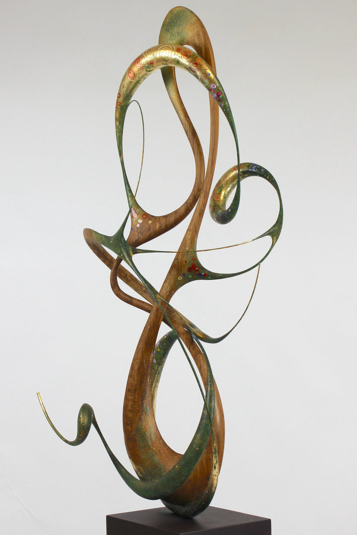 How Was I to Know by Mark Purllant, a one-off mixed media sculpture in carved English brown oak with intertwining flowing forms, enriched with painted details and 23ct gold leaf accents, evoking Gustav Klimt’s decorative influence.