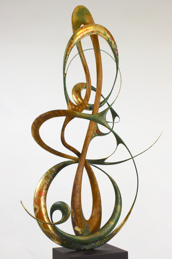 How Was I to Know by Mark Purllant, a one-off mixed media sculpture in carved English brown oak with intertwining flowing forms, enriched with painted details and 23ct gold leaf accents, evoking Gustav Klimt’s decorative influence.