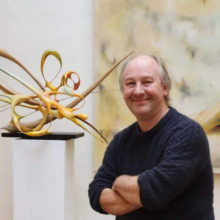 Oil Painting in Sculpture 11.1 by Mark Purllant, a one-off mixed media piece in carved English oak with sculpted oil-painted forms in vivid yellow, orange, and pale blue tones, dynamic and fluid, mounted on a dark base.