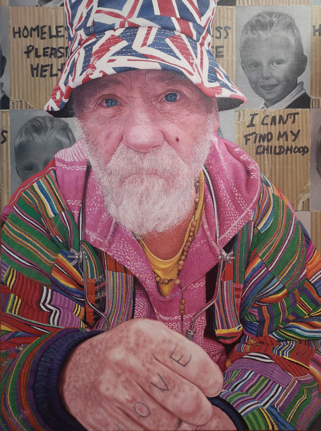 Mick by James Earley — a hyperrealist oil painting of an elderly homeless man in a colourful patchwork jacket and Union Jack bucket hat, staring directly at the viewer with blue eyes full of depth and resilience, his knuckles spelling “LOVE.” Behind him, cardboard signs and childhood photos evoke themes of loss, survival, and invisible trauma.