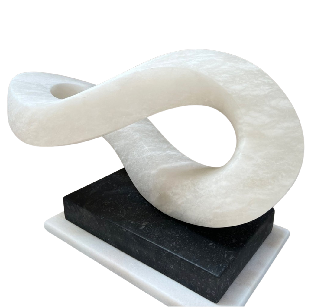 Abstract alabaster sculpture Meander – 2024 by Hamish Holman, hand-carved from Spanish alabaster into a fluid looping infinity-like form with soft translucent white tones, displayed on a contrasting dark stone base.