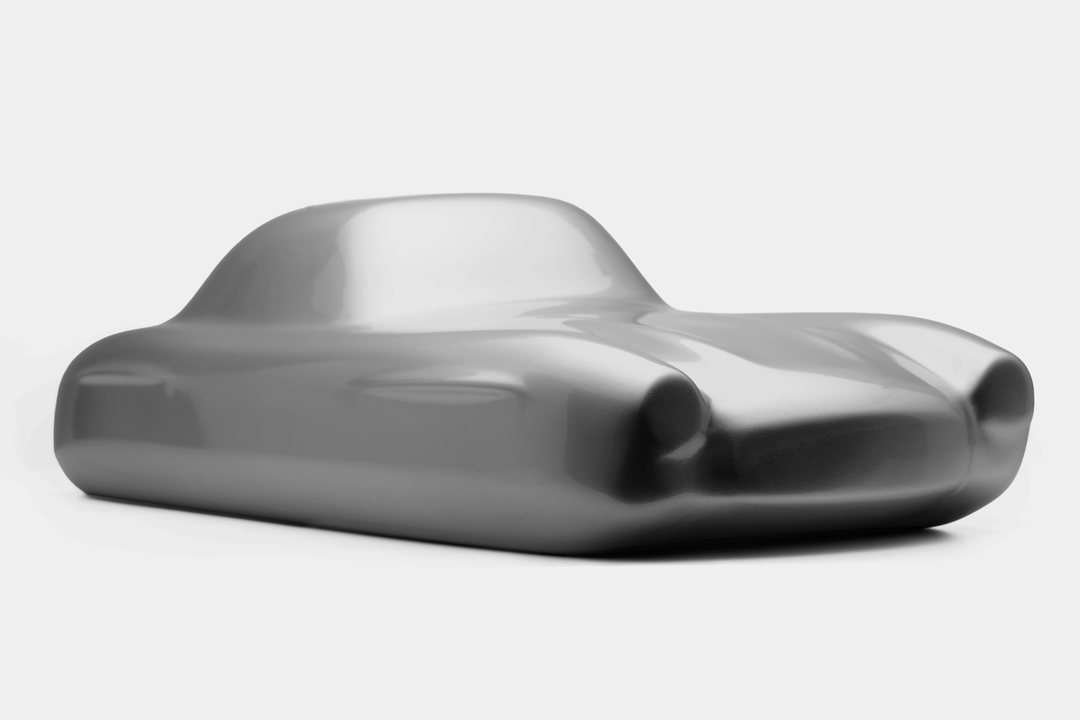 ‘Mercedes 300SL’ by Srini Gandra, a limited-edition contemporary automotive sculpture from the Forme di Velocità series, inspired by the iconic Mercedes-Benz 300 SL Gullwing. Presented in an elegant Silver Grey metallic finish, the sculpture captures the classic sports car's elongated bonnet, distinctive rounded front wings, low-slung body, sculpted side contours and gracefully curved roofline. Its smooth, minimalist surfaces celebrate the aerodynamic elegance, timeless proportions and pioneering design of 