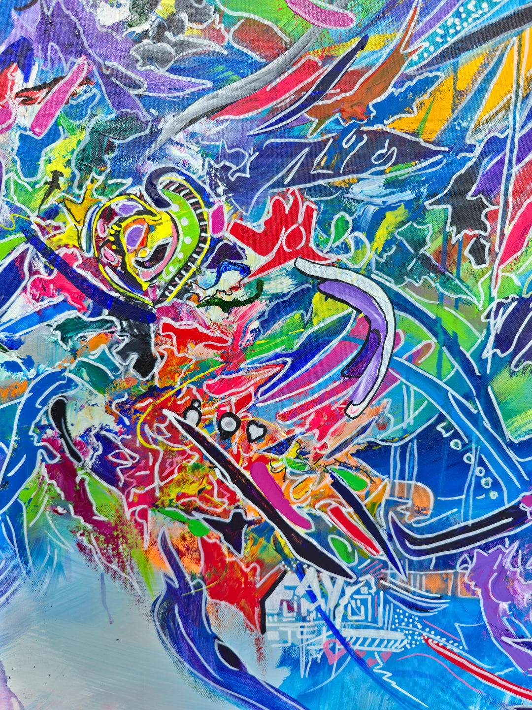 Vibrant large-scale abstract graffiti painting bursting with layered colour, bold sweeping lines and dynamic shapes against a bright blue background, framed in a white tray frame.