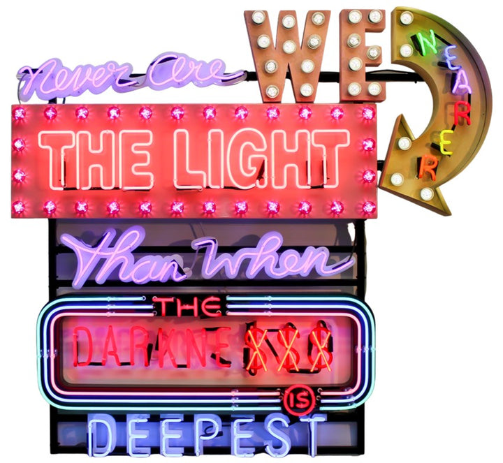 Marcus Bracey with Neon wall artwork featuring the phrase “Never Are We Nearer The Light Than When The Darkness Is Deepest” in layered typography. Includes fabricated metal panels, red marquee lights, a retro arrow lit with cabochon LEDs, and vivid neon lettering in magenta, violet, red, blue, turquoise, orange, and white. A glowing, multicoloured composition by Chris Bracey reflecting spiritual insight and emotional depth.