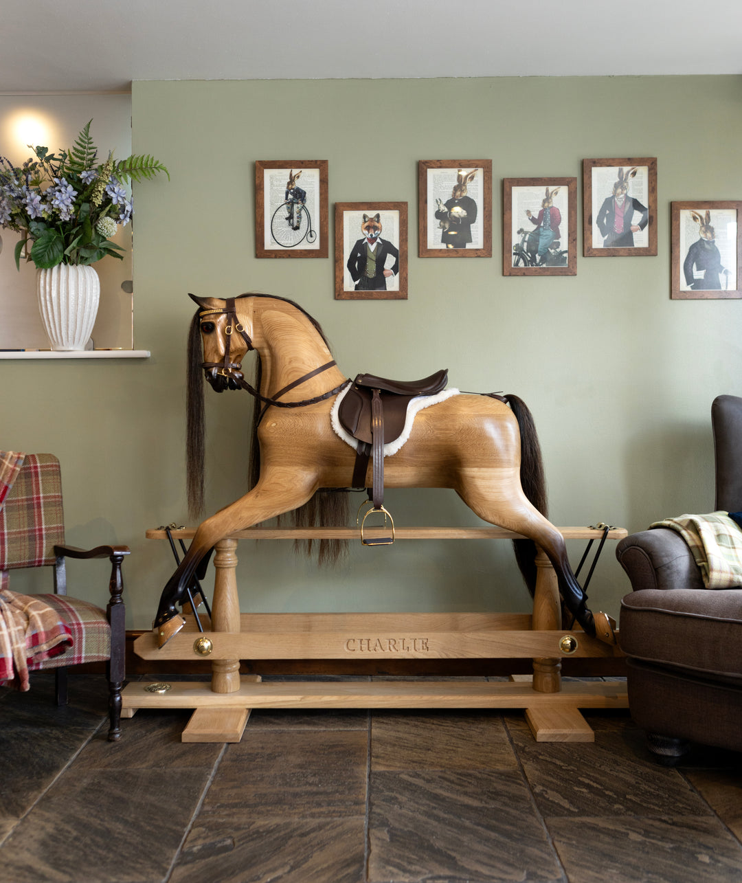 Hand-carved wooden rocking horse with leather saddle, set in a traditional living room with characterful decor.

