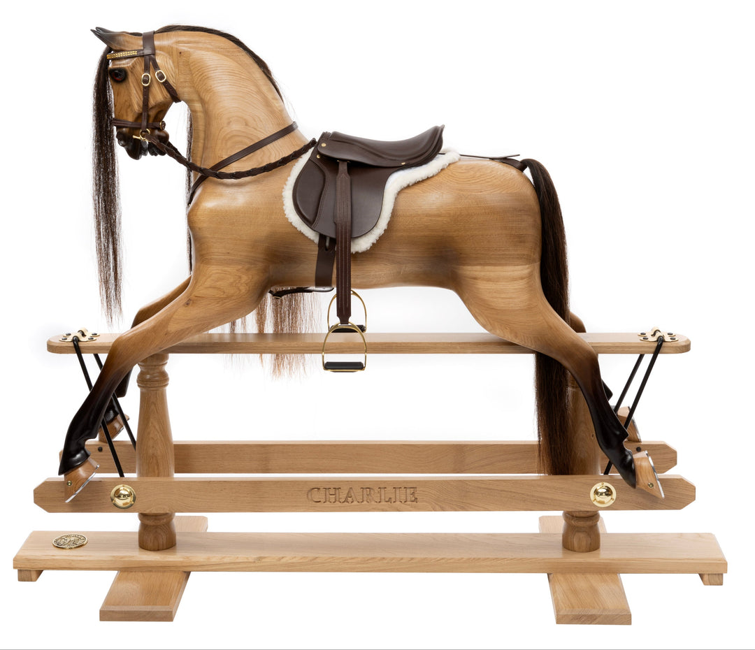 Hand-carved wooden rocking horse with leather saddle, set in a traditional living room with characterful decor.
