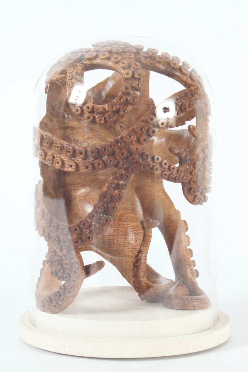 Hand-carved wooden octopus sculpture by Bill Prickett, carved from English oak burr and enclosed within a clear glass dome, its detailed tentacles pressed against the curved surface and mounted on a Portland stone base.