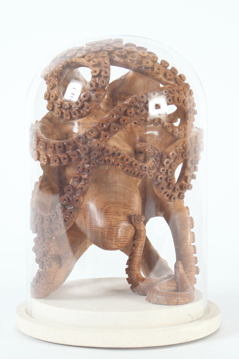 Hand-carved wooden octopus sculpture by Bill Prickett, carved from English oak burr and enclosed within a clear glass dome, its detailed tentacles pressed against the curved surface and mounted on a Portland stone base.