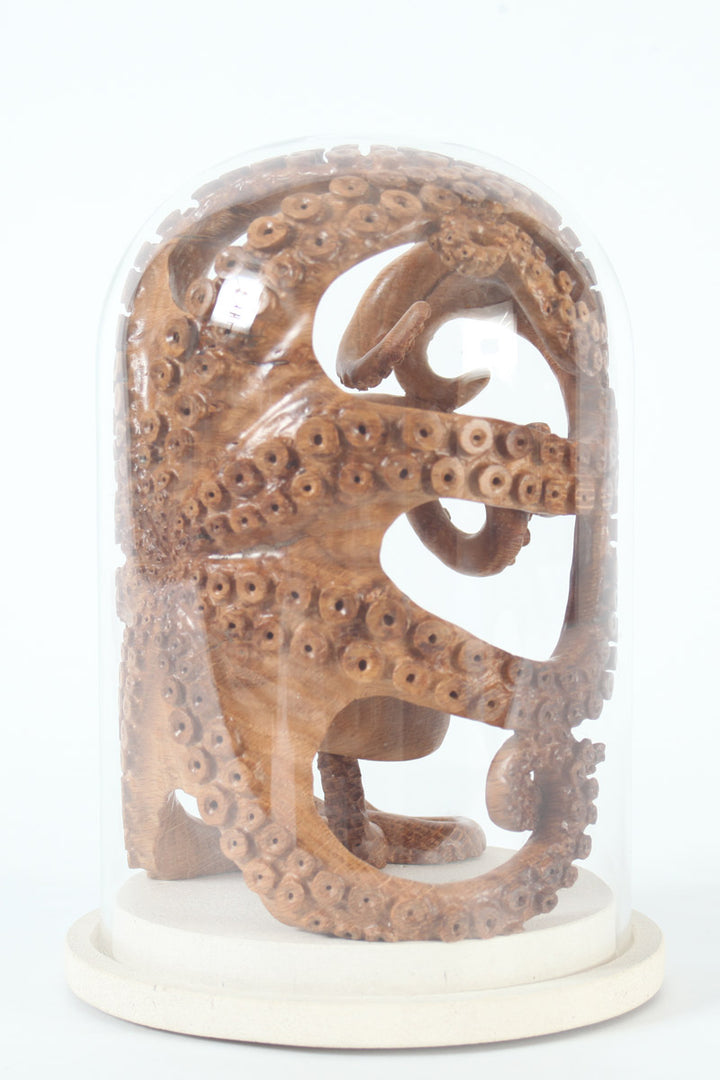 Hand-carved wooden octopus sculpture by Bill Prickett, carved from English oak burr and enclosed within a clear glass dome, its detailed tentacles pressed against the curved surface and mounted on a Portland stone base.