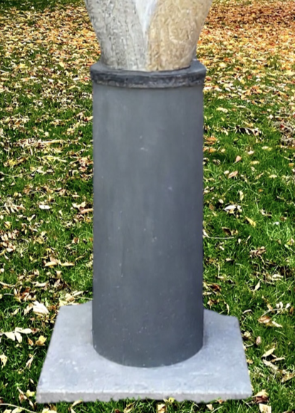 Offspring by Martin Cash — a hand-carved Ancaster Weatherbed stone sculpture mounted on a granite base. The tall, abstract form features two intertwined organic shapes, symbolising growth and unity, designed for display in gardens or public spaces.