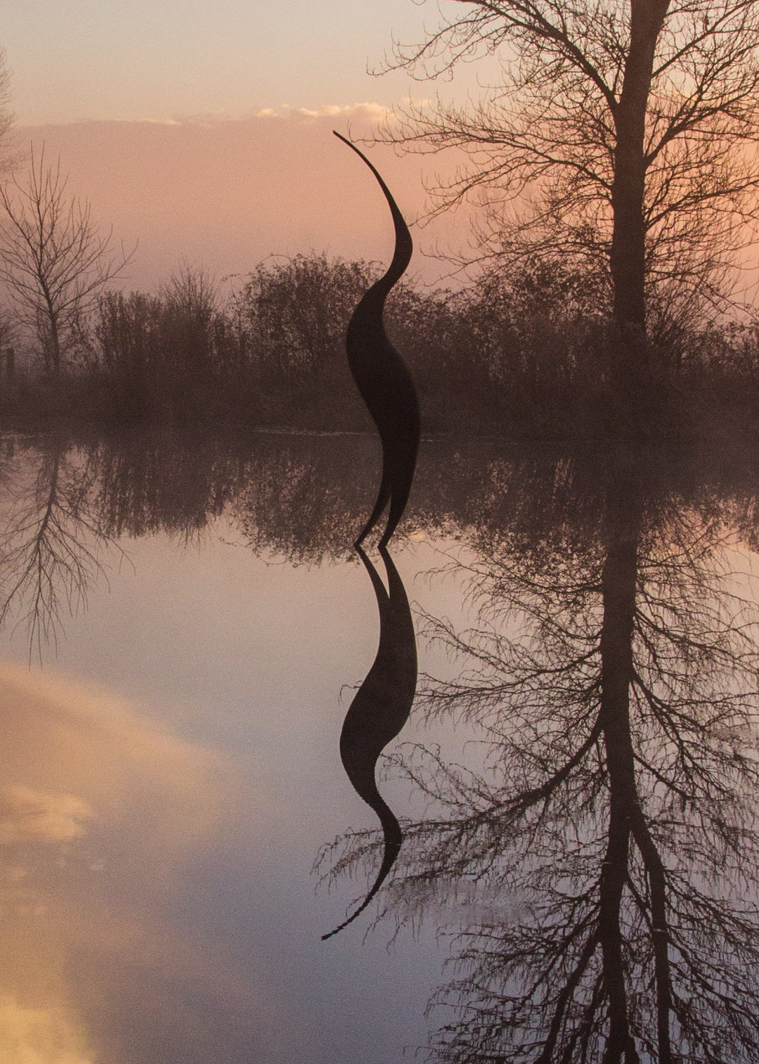 Simon Gudgeon bronze sculpture Origins featuring a tall abstract organic bird-inspired form with elegant flowing curves displayed within a landscaped outdoor setting.