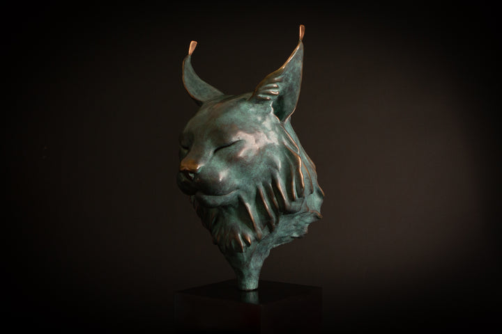 Petra Eurasian Lynx bronze sculpture by Min Reid, serene lynx head with closed eyes and pointed ear tufts in green verdigris bronze with warm copper highlights, mounted on a black plinth, contemporary wildlife bronze sculpture